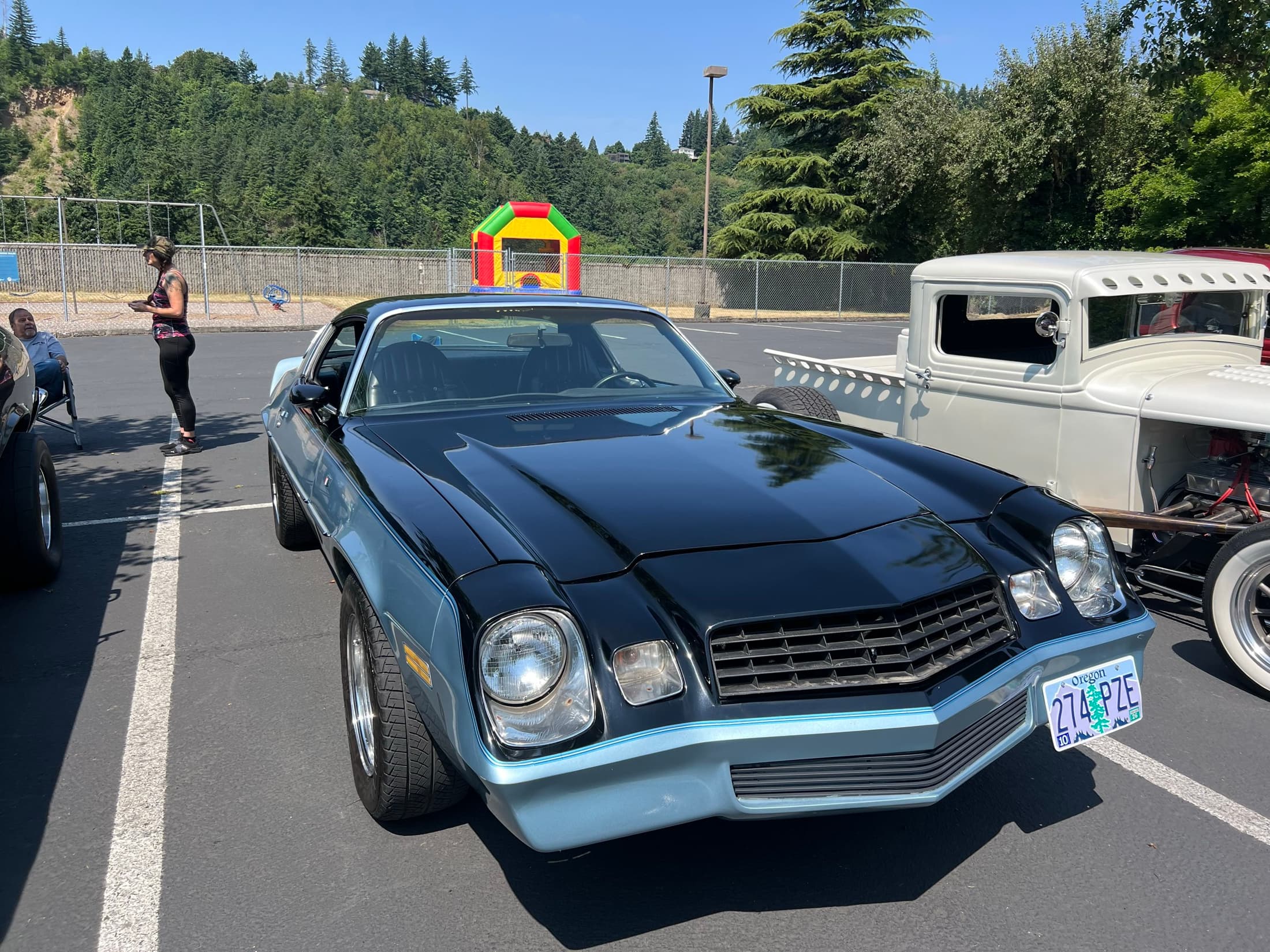 Black Camaro parked near the playground.